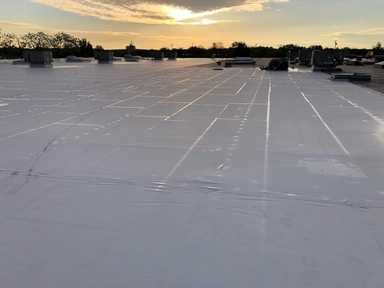 Completed white spray-applied roof system on a Maryland commercial building